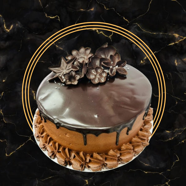 Rich chocolate cake with glossy ganache and chocolate flower decorations