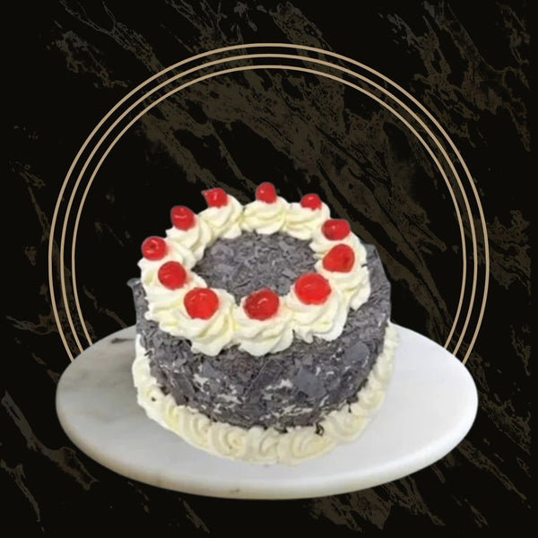 Black Forest cake topped with whipped cream swirls and glazed cherries from The Bakers Shop in Birmingham