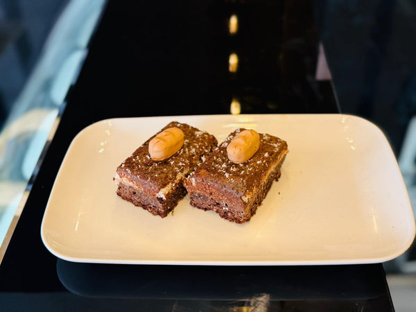 Two brownies on a white plate with a blurred background