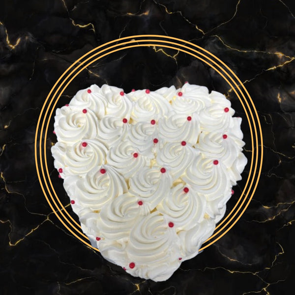 Heart-shaped white rosette cream cake decorated with red pearls on a black marble background