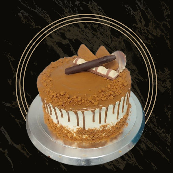 Heart-shaped Lotus cake with caramel drip and biscuit garnish from The Bakers Shop in Birmingham